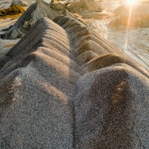Drone shot of sunlit gravel formations in Rochester, MN quarry, showcasing natural textures.